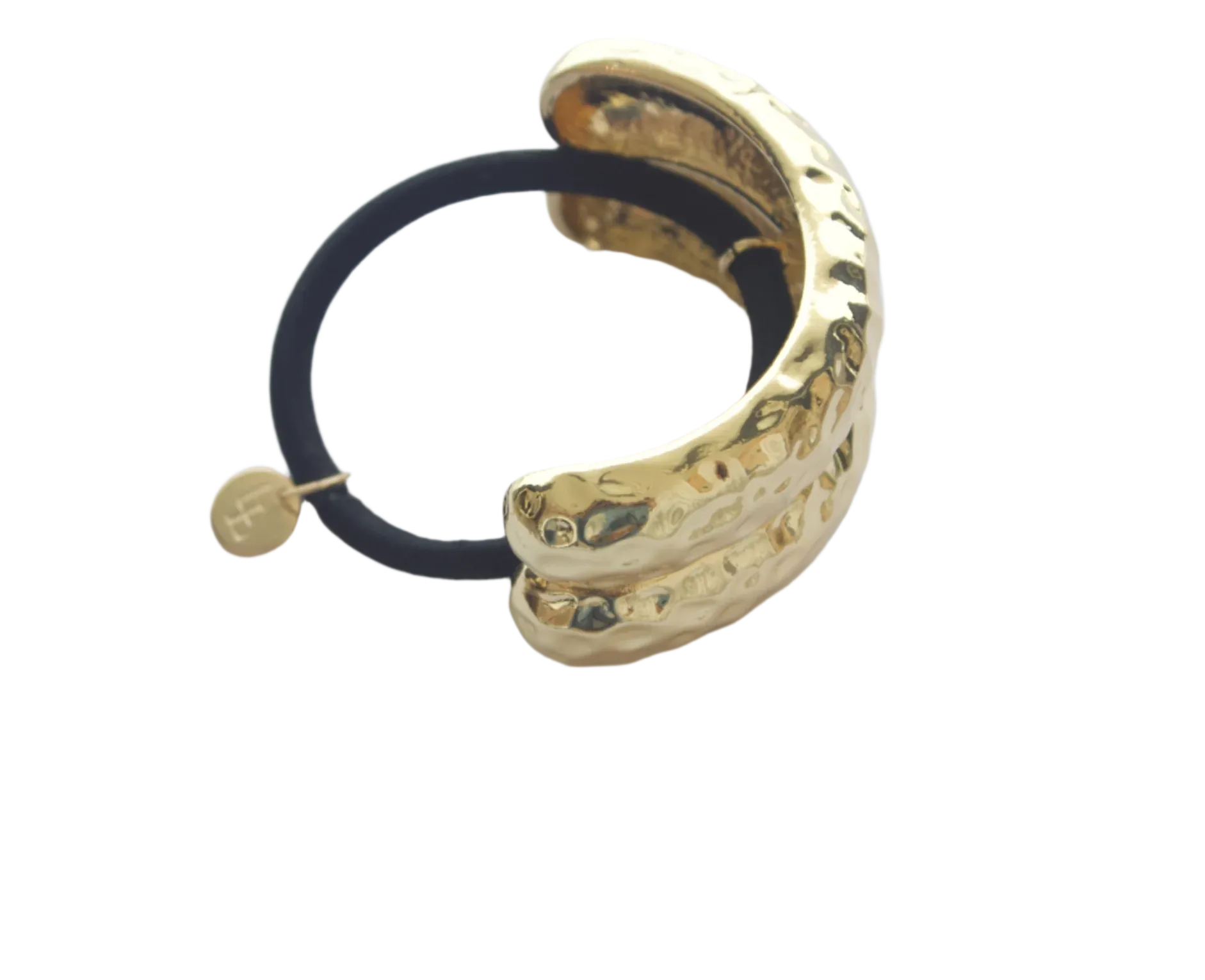 Gold hair tie with black elastic on a light gray background