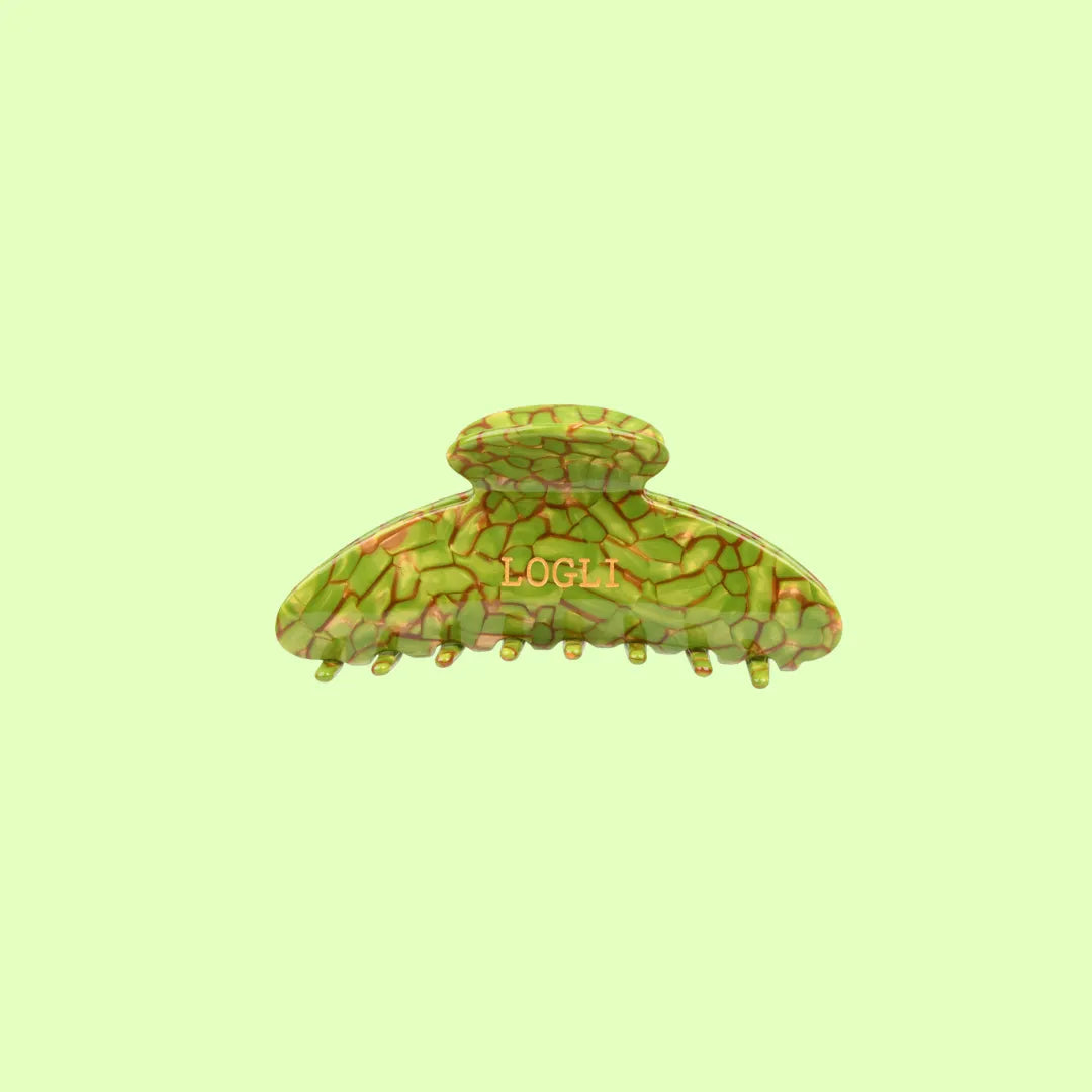 Green and gold patterned hair clip on a light green background