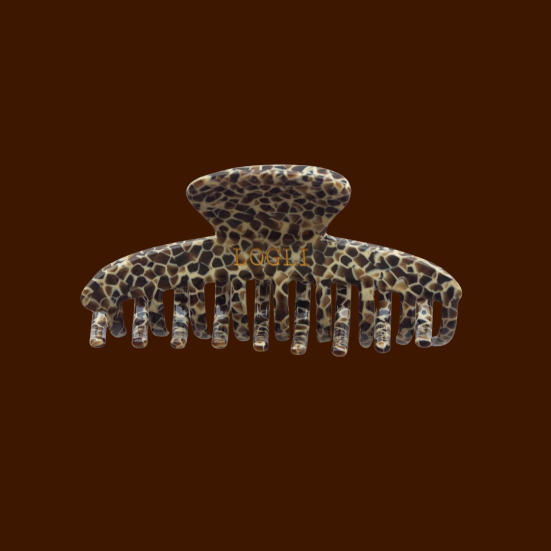 Leopard print hair clip on a dark brown background